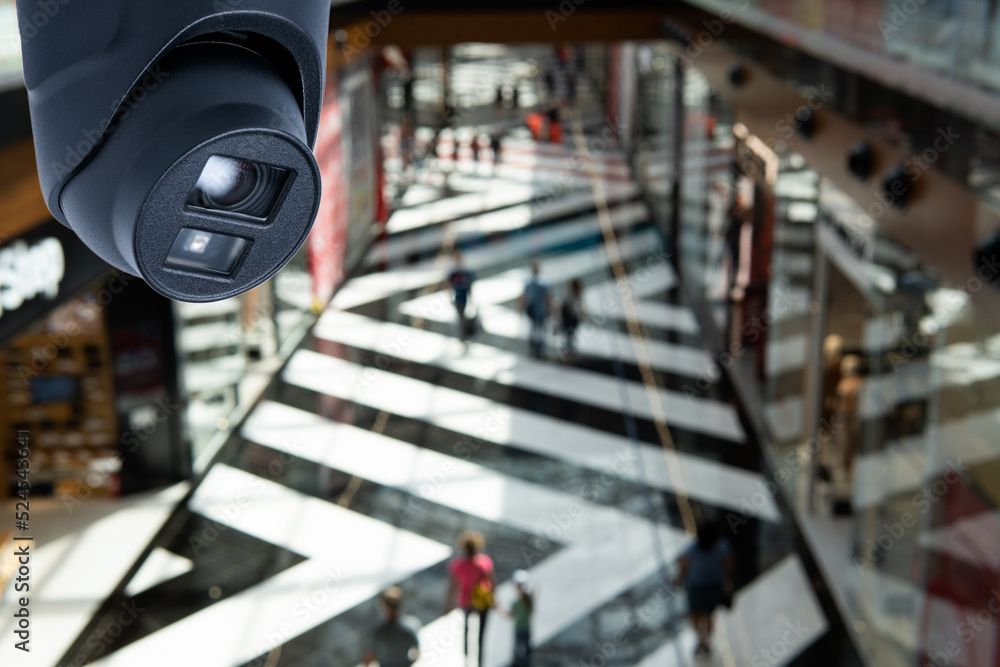 Obraz premium CCTV security camera on blur people in food center or shopping mall.