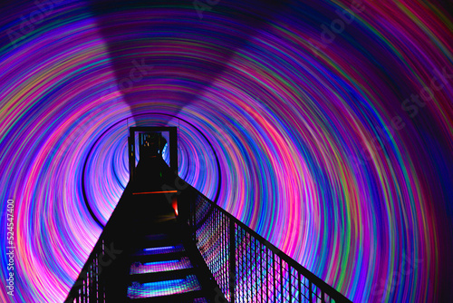 Bridge in a circular light tunnel with pink and purple