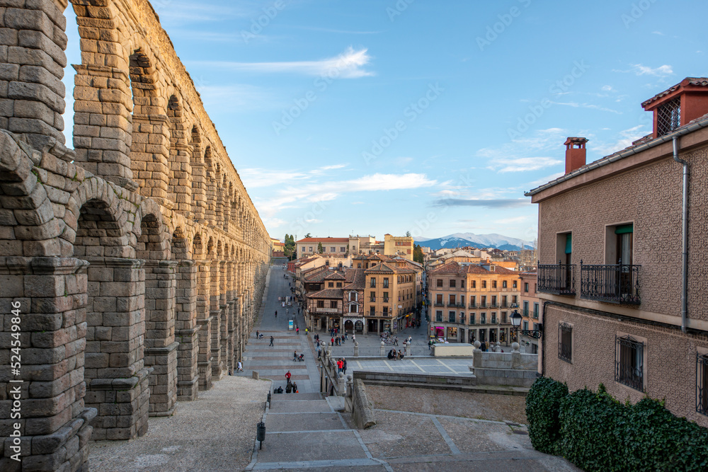 Views of the city of Segovia in the shadow of the Roman aqueduct and the snowy mountains in the background