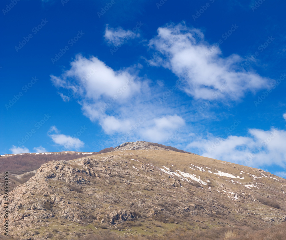 mountain ridge on blue cloudy sky background