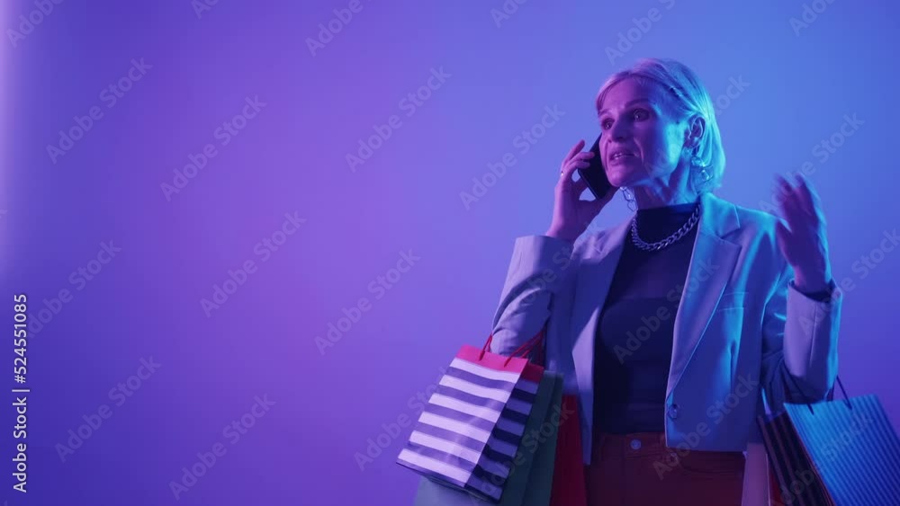 Customer complaint. Bad service. Shopping feedback. Frustrated angry woman client disappointed with fake product purchase arguing on phone call in neon light copy space.