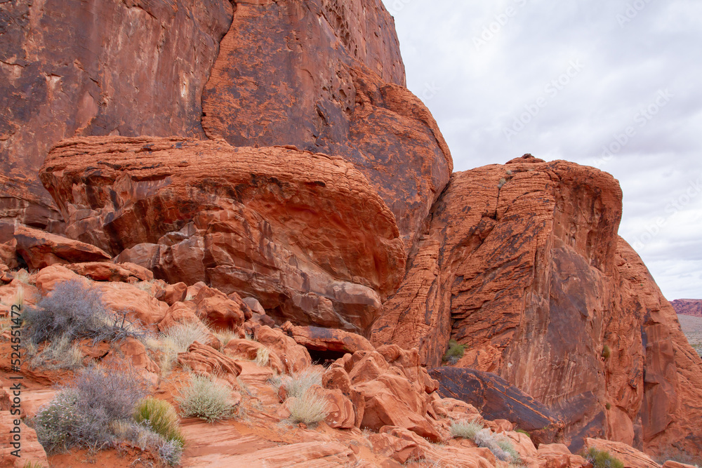 mountainside environment in the American southwest, red sandstone boulders are weathered away by the wind and deposit a fine sand onto the top layer of ground