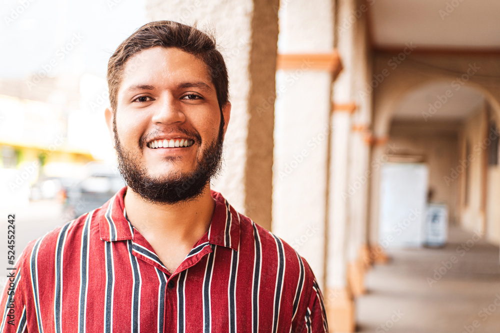 Obraz premium closeup portrait of a young latin american man smiling looking at camera