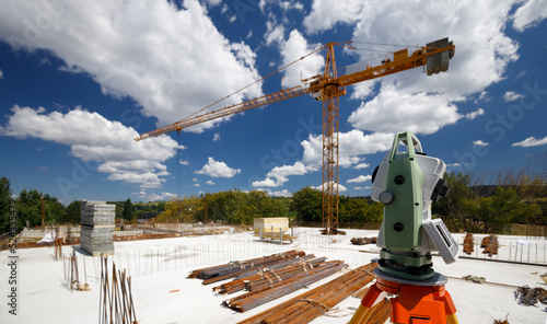 Φωτογραφία The work of a surveyor with a total station on a high-rise apartment building du