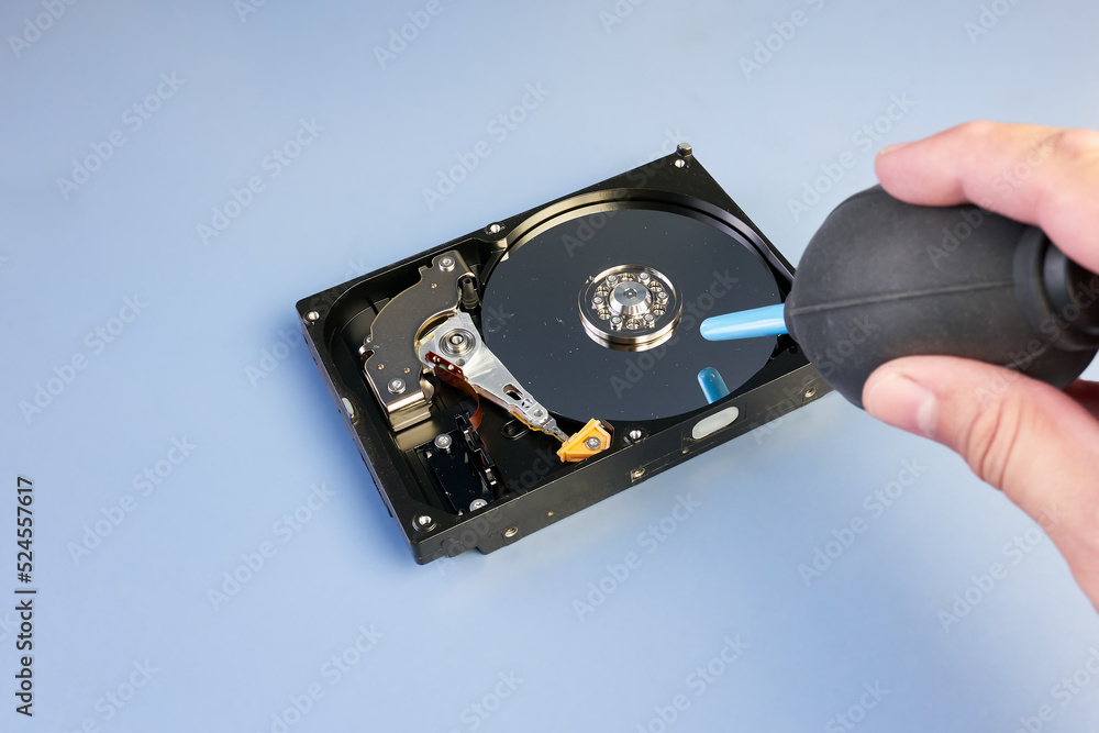 Disassembled computer hard disk drive with dust and rubber air blower. HDD repair, Data Recovery, data protection. Rubber bulb air pump dust blower cleaning. Broken tightness of the hard drive. Disassembled computer hard disk drive with dust and rubber air blower. HDD repair, Data Recovery, data protection. Rubber bulb air pump dust blower cleaning. Broken tightness of the hard drive.