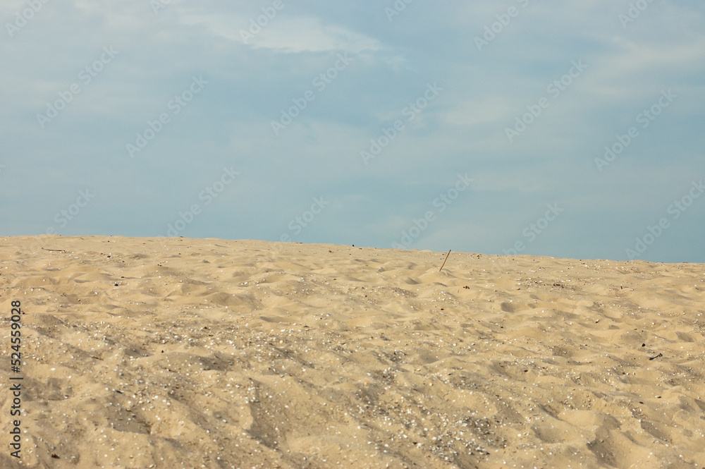 sand mountain, in the photo a large mountain of sand, blue sky in the background sand mountain, in the photo a large mountain of sand, blue sky in the background