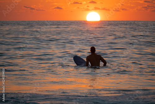 Obraz na płótnie Silhouette of Surfer waiting on the line up for a wave at sunrise or sunset w salonie