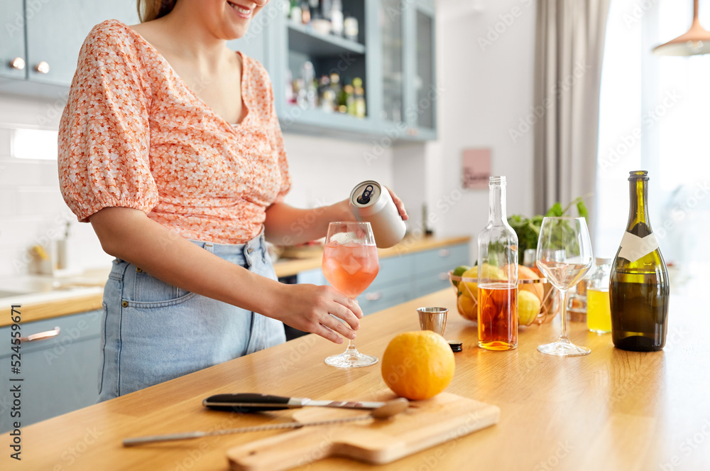 © Syda Productions - drinks and people concept - close up of woman pouring soda from tin can to wine glass and making orange cocktail at home kitchen © Syda Productions - drinks and people concept - close up of woman pouring soda from tin can to wine glass and making orange cocktail at home kitchen
