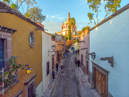 Aerial Drone Shot From Narrow street in San Miguel de Allende Cathedral at evening light in Guanajuato, Mexico © Oleksandr