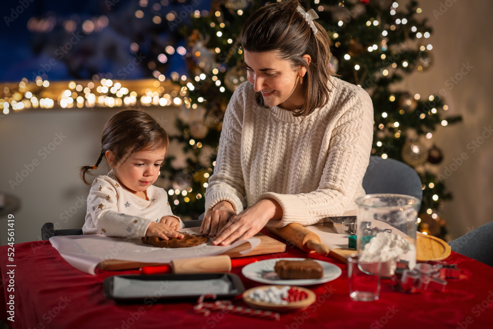 family, cooking and winter holidays concept - happy mother and baby daughter having fun with dough for gingerbread cookies at home on christmas family, cooking and winter holidays concept - happy mother and baby daughter having fun with dough for gingerbread cookies at home on christmas