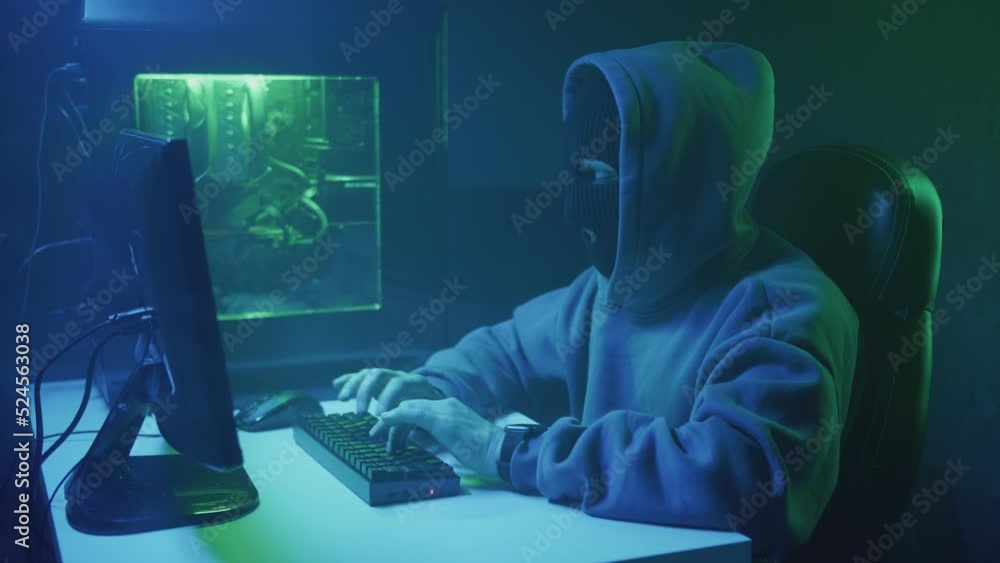 Cybercriminal hacker typing and looking at the clock on his hand. High quality 4k footage Cybercriminal hacker typing and looking at the clock on his hand. High quality 4k footage
