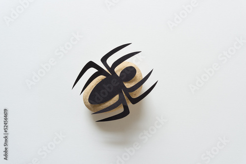 paper spider isolated on a yellow rock and white space