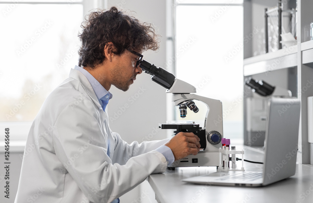 science research, work and people concept - male scientist with microscope working in laboratory science research, work and people concept - male scientist with microscope working in laboratory