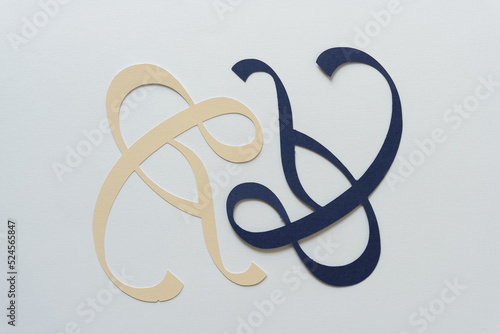 two ampersands in ivory and blue on blank paper
