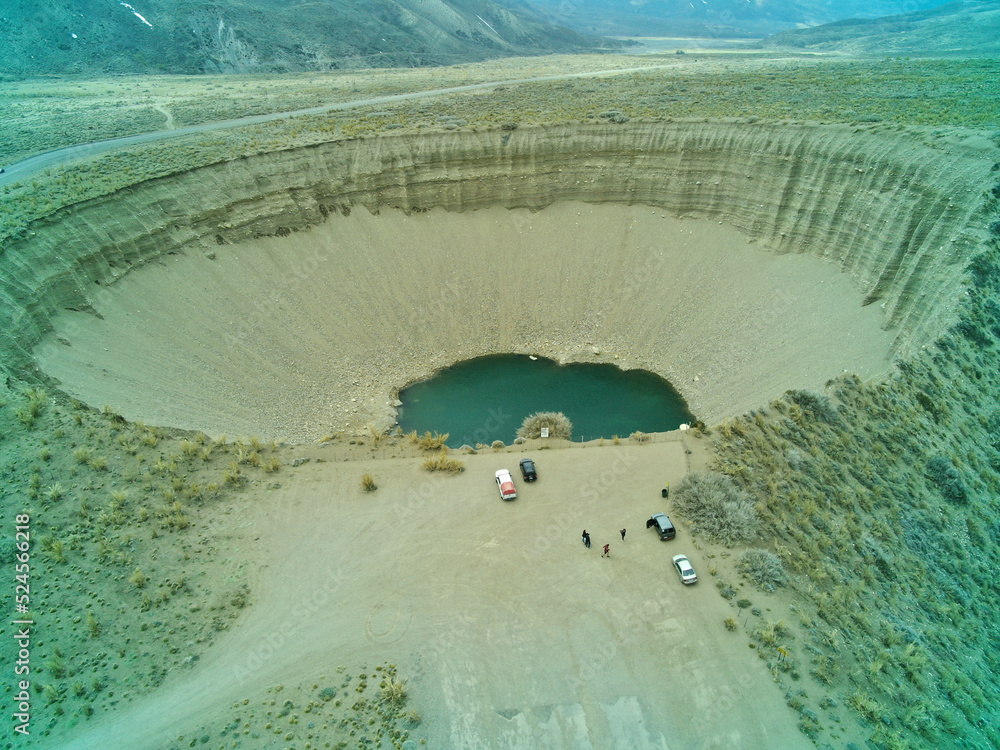 Vista de un pozo gigante natural en la tierra, con agua en el fondo ...