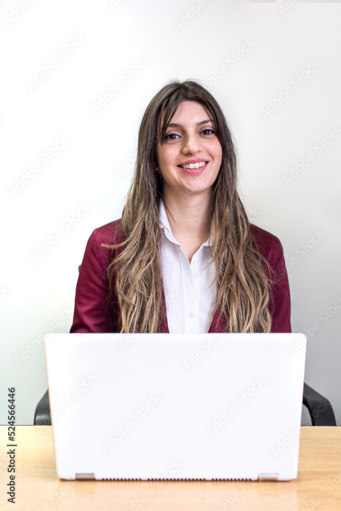 Beautiful smiling woman working on her laptop while looking at camera Beautiful smiling woman working on her laptop while looking at camera