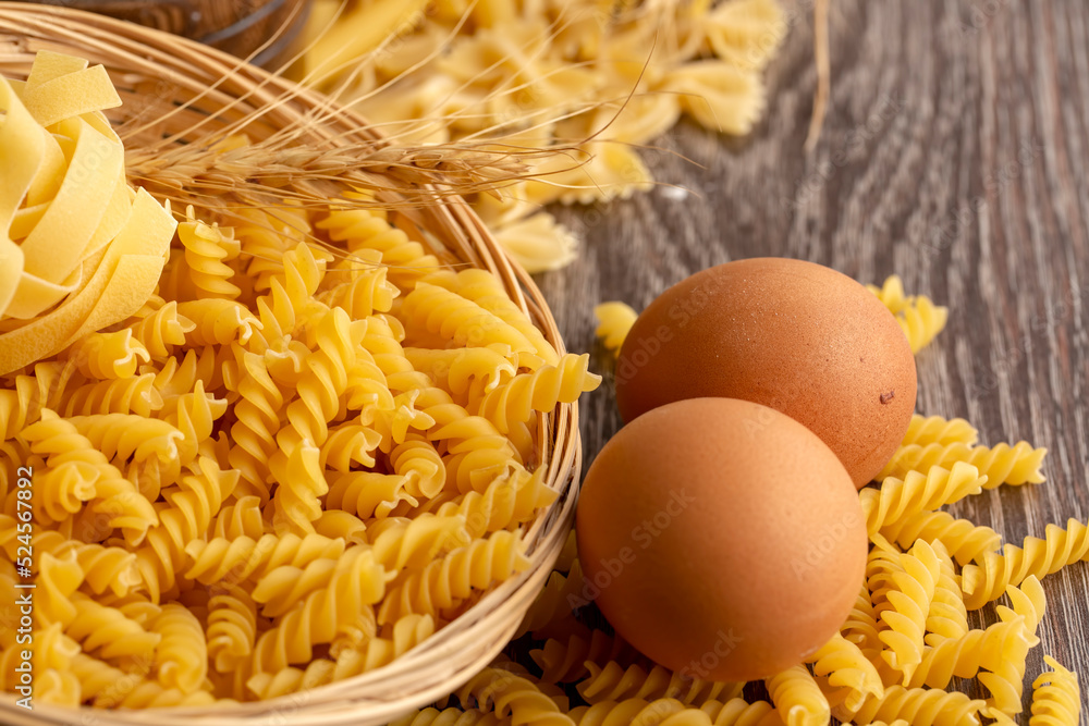 Pasta and eggs on the wooden background