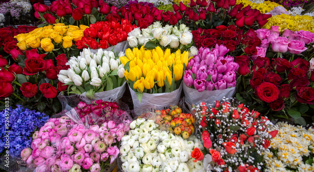 Colorful variety of flowers, tulips, roses, florist's bench