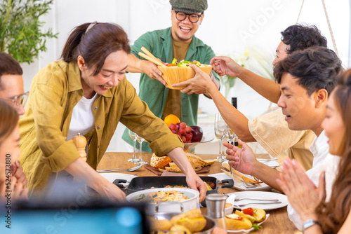 Canvas Print Group of Asian man and woman friends having dinner with drinking wine and talking together on dining table at home