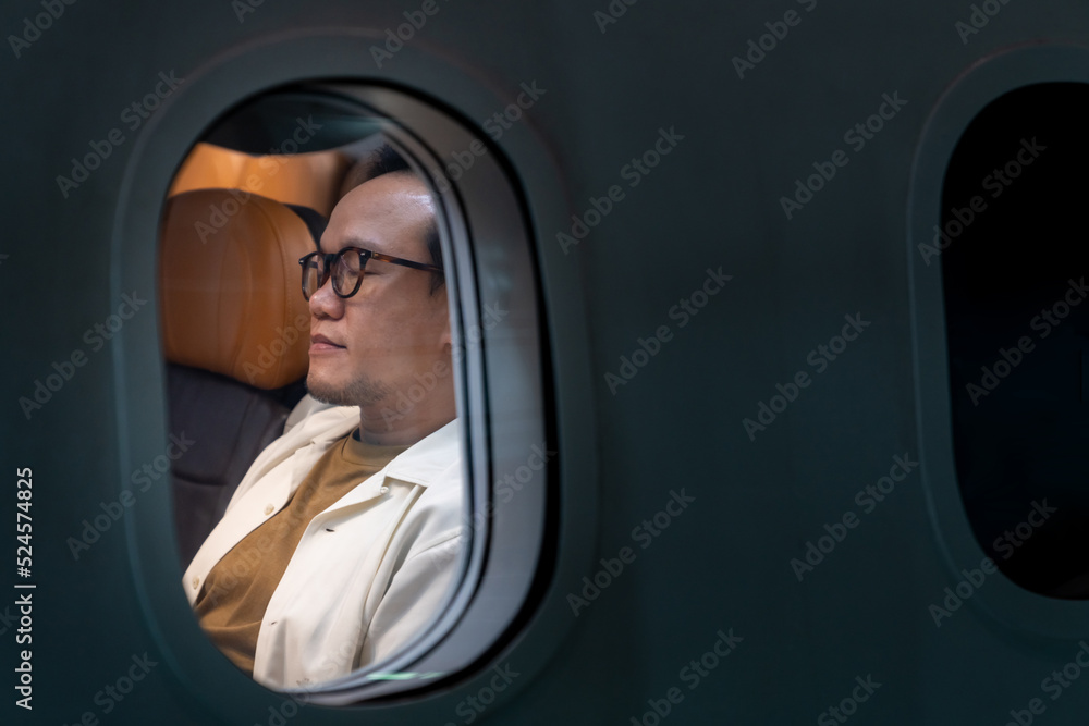 Asian man passenger sitting in airplane and sleeping on the seat while travel by aircraft on summer vacation. Commercial Airline service business and holiday vacation concept. Asian man passenger sitting in airplane and sleeping on the seat while travel by aircraft on summer vacation. Commercial Airline service business and holiday vacation concept.