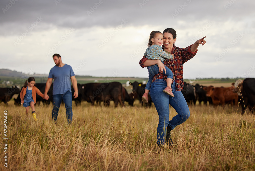 Happy family bonding on a cattle farm, walking and looking at animals,  relaxing outdoors together. Young