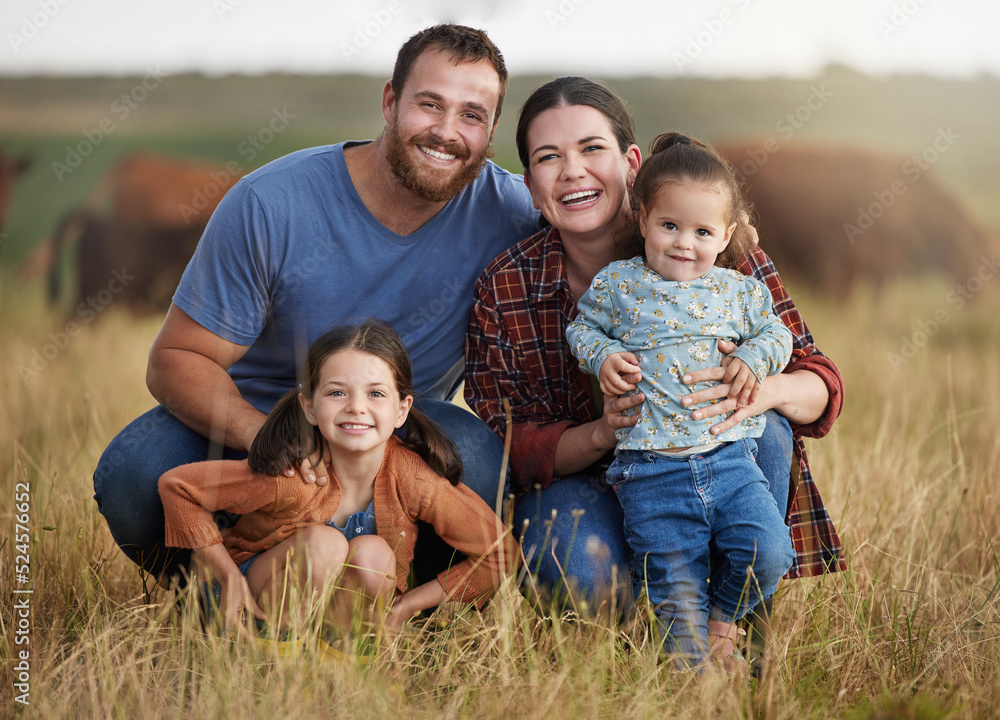 Portrait of happy family on a countryside farm field with cows in the background. Farmer parents bonding with kids on a sustainable agriculture cattle business with a smile and happiness together Portrait of happy family on a countryside farm field with cows in the background. Farmer parents bonding with kids on a sustainable agriculture cattle business with a smile and happiness together