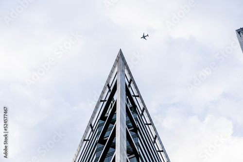 airplane flying over skyscraper in city
