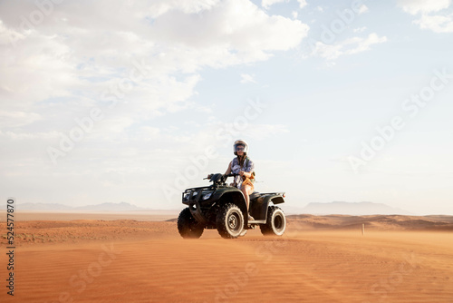 female traveler riding quad bike through desert of namibia photo