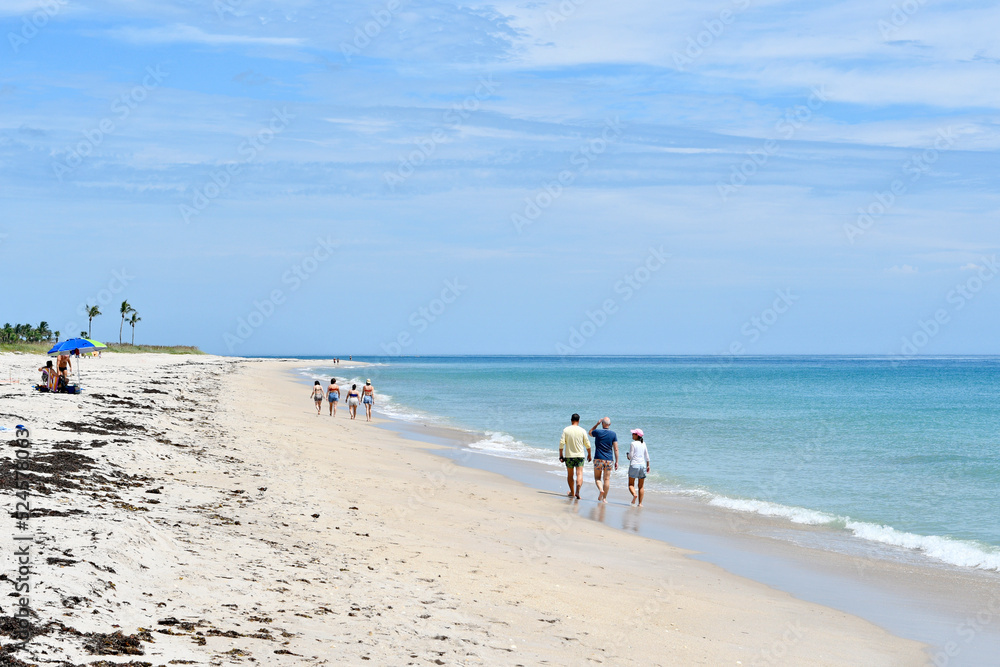 Groups of people walking along a quiet, uncrowded beach in Vero Beach, Florida on Hutchinson Island Groups of people walking along a quiet, uncrowded beach in Vero Beach, Florida on Hutchinson Island