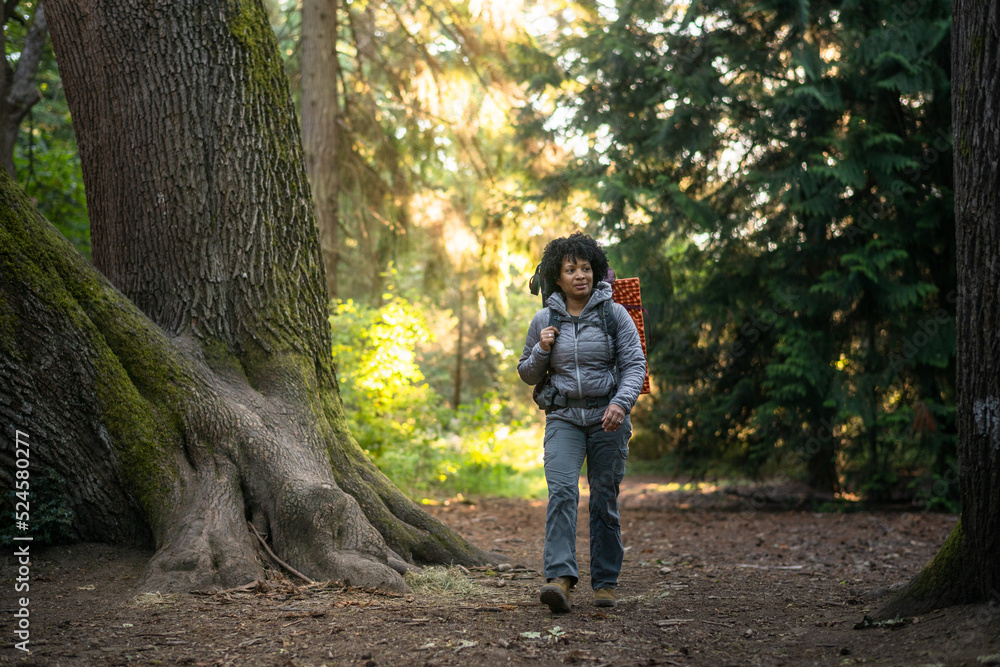 Naklejka premium U.S. Army female soldier putting in the miles with an early morning hike in the NorthWest.