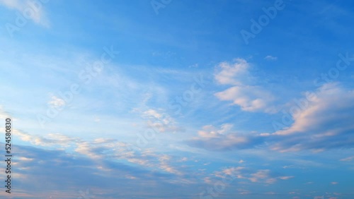 Floating fluffy clouds. Two layers of cloudiness. Blue summer sky with clouds moving in different directions. Time lapse.