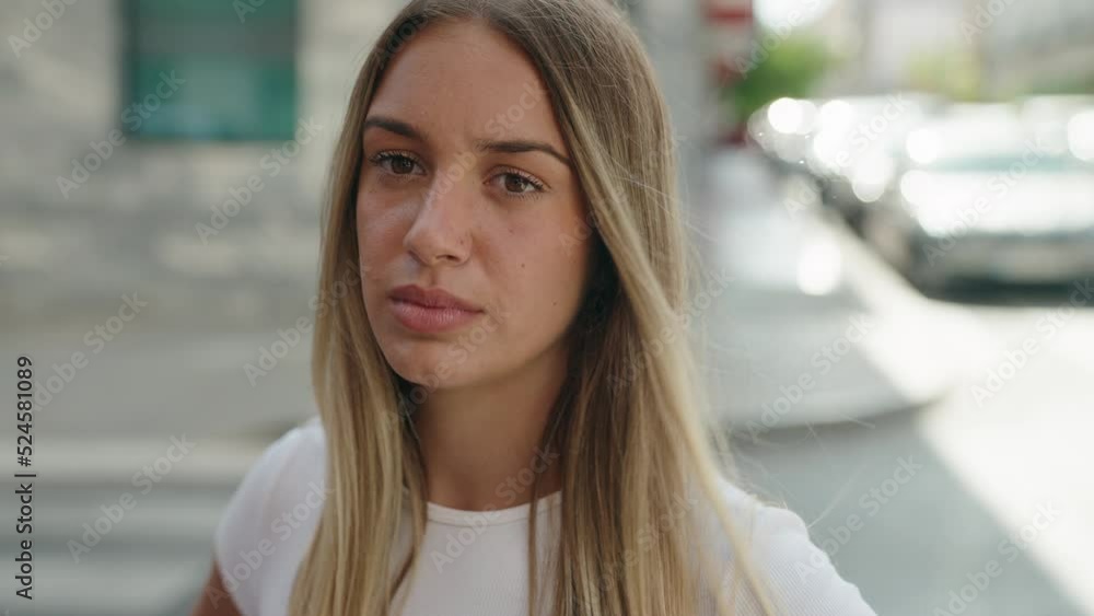Young beautiful hispanic woman looking to the camera with serious expression at street Young beautiful hispanic woman looking to the camera with serious expression at street