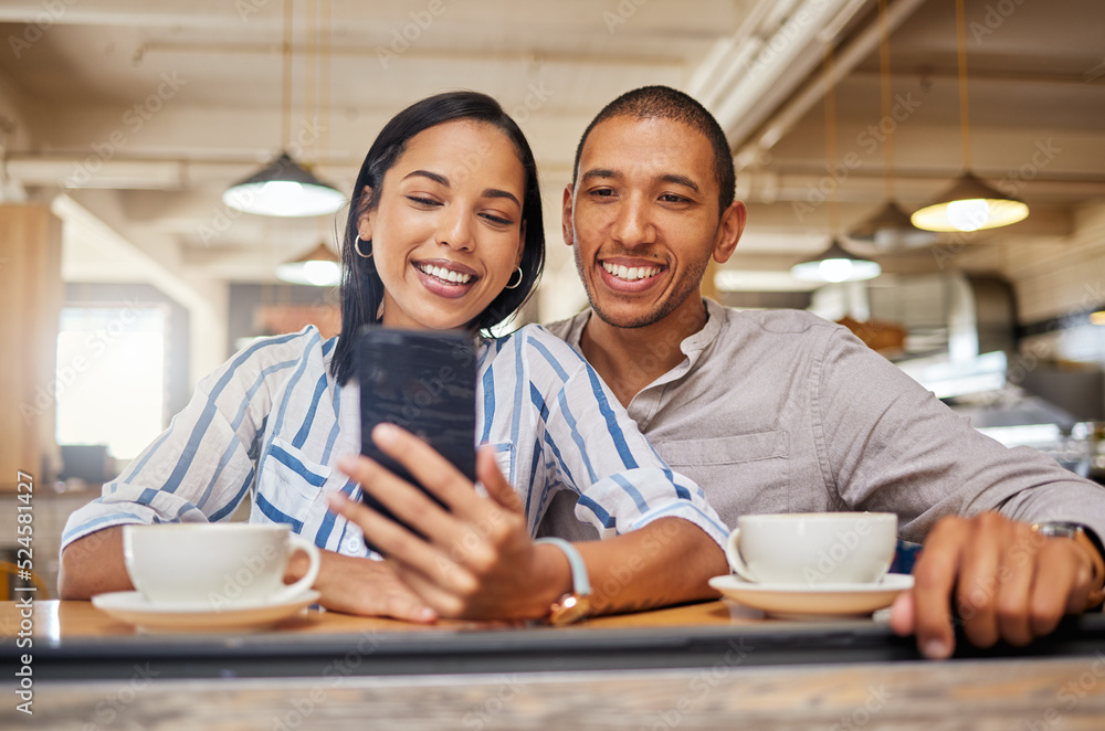 Happy couple on a video call on phone, bonding on a coffee date at a cafe or restaurant, taking a selfie. Young girlfriend and boyfriend browsing online, checking social media and relaxing together