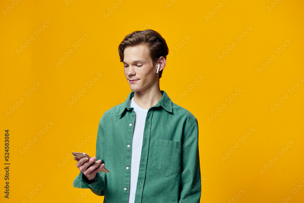 portrait of a man talking through wireless headphones on the phone and standing sideways to the camera portrait of a man talking through wireless headphones on the phone and standing sideways to the camera