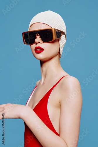 A stylish woman in a swimming cap and a fashionable red swimsuit