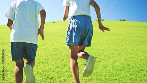 青空の公園を走るアジア人の子供