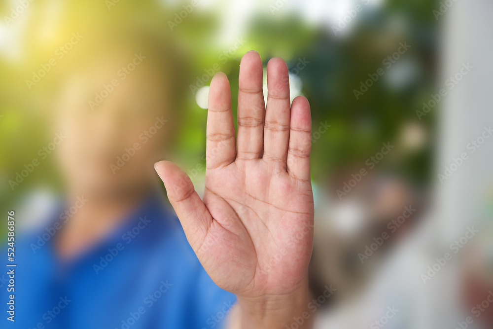 Man showing stop gesture with blurred body close up of the hand Man showing stop gesture with blurred body close up of the hand