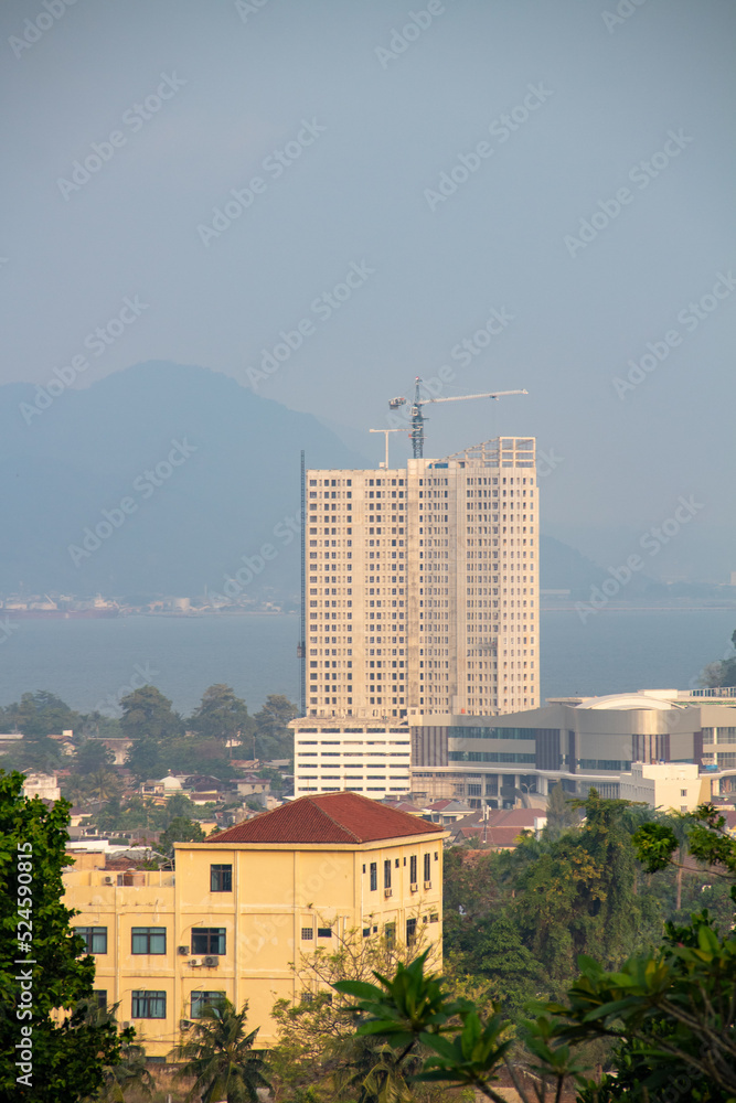 The backdrop of the tall white building on the outskirts of the city