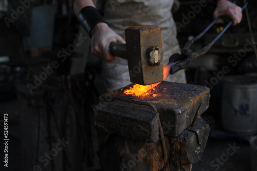 Almaty, Kazakhstan - 09.24.2015 : A blacksmith makes a metal holder for knives and tools in the workshop.