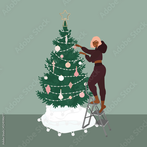 Girl decorating christmas tree with baubles and garlands