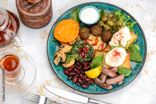 oriental breakfast with egg greens sausages in blue on background with tea top view 