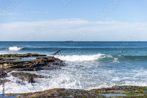 Surfer diving in waves