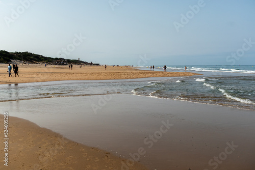 people walking along the seashore, early in the morning, at La Barrosa beach in Sancti Petri, Cadiz, Spain