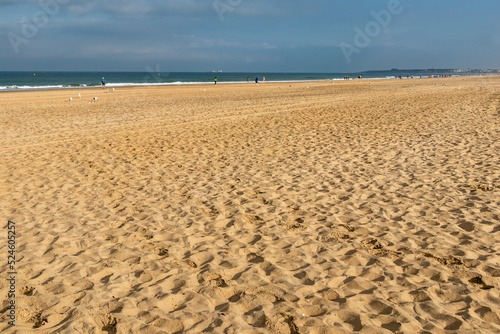 people walking along the seashore  early in the morning  at La Barrosa beach in Sancti Petri  Cadiz  Spain