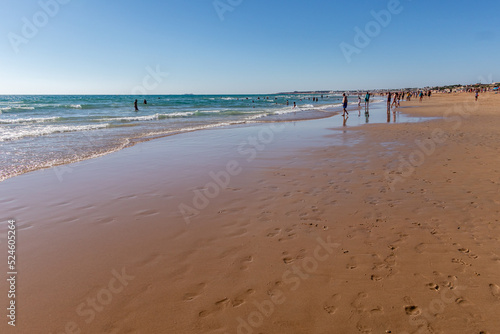 people walking along the seashore, early in the morning, at La Barrosa beach in Sancti Petri, Cadiz, Spain