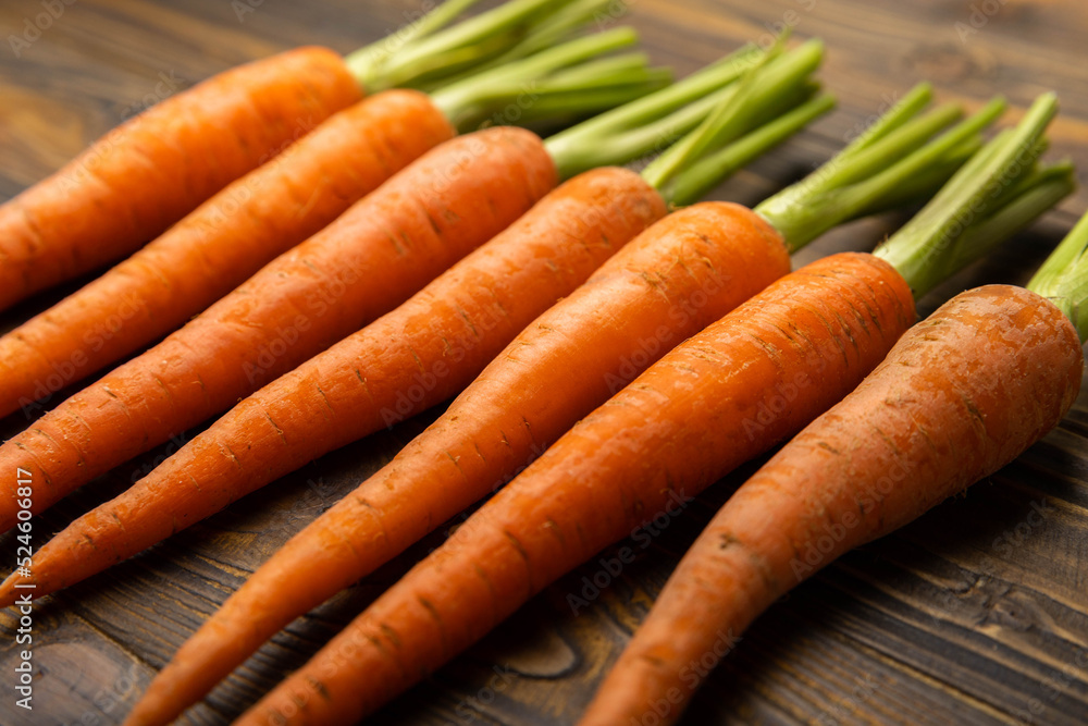 Fresh carrots on brown texture background. Ingredient for salad.Vegetarian organic vegetables.Healthy food.Copy space.Place for text Fresh carrots on brown texture background. Ingredient for salad.Vegetarian organic vegetables.Healthy food.Copy space.Place for text
