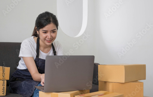 Starting Small business entrepreneur freelance,Portrait young woman working at home office, BOX,smartphone,laptop, online, marketing, packaging, delivery, SME, e-commerce concept © wichayada