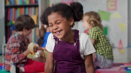 Close up portrait of smiling little African-American girl looking at camera at primary school