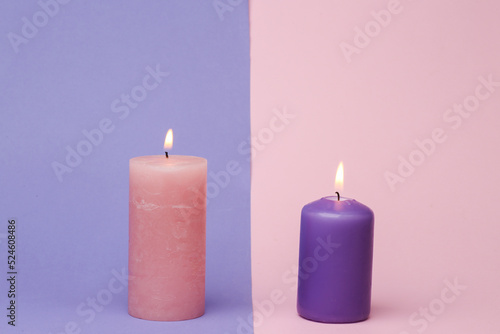 Flaming candles on a pink-violet background. Pastel color trend