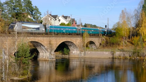 Vy train crossing river in Honefoss, Buskerud, Norway